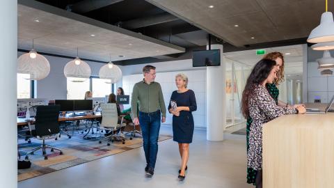 Twee collega's lopen door de hal van de gemeente