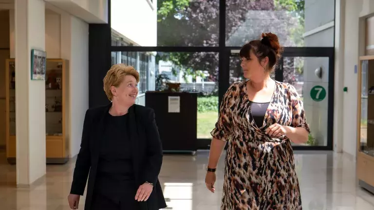 Gastvrouw Loes loopt over de gang met jobcoach Lenca